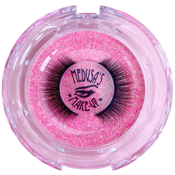 Pink glittery container with false eyelashes branded 'Medusa's Make Up' on a white background
